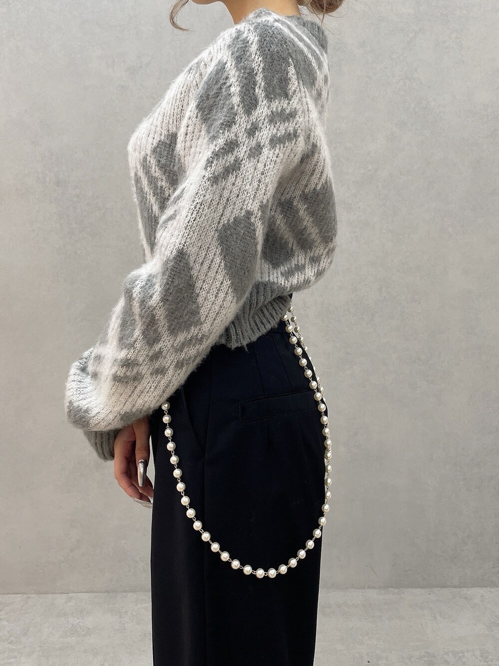 グレー系のニット/セーター、ブラック系のその他パンツ、ブラック系のブーツを着用したレディースの秋コーディネートの8枚目の写真