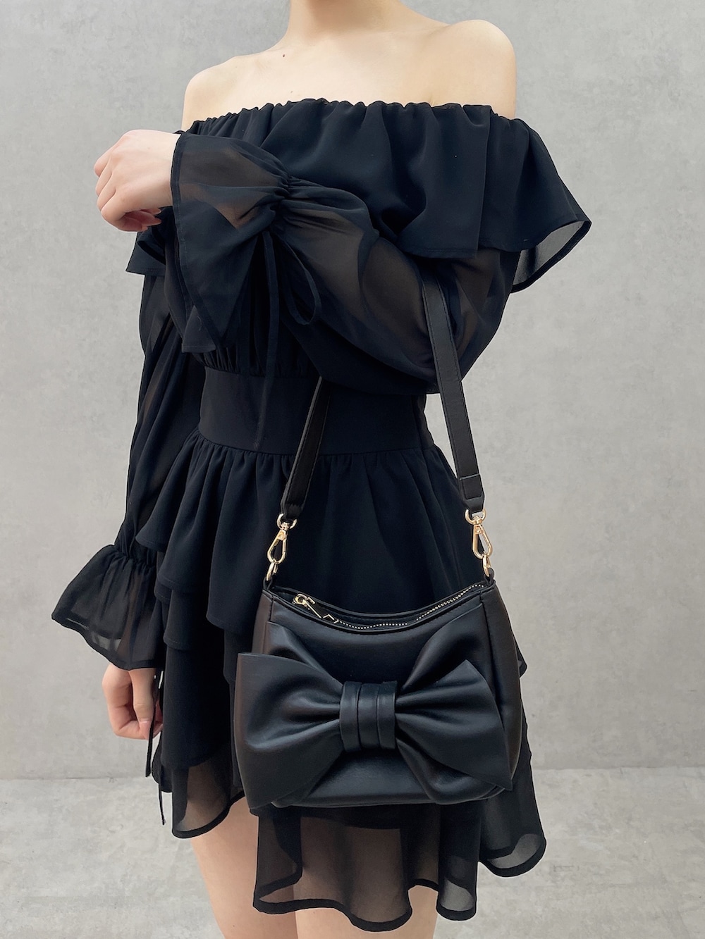 ブラック系のワンピース、ブラック系のハンドバッグ、ブラック系のサンダルを着用したレディースの春コーディネートの7枚目の写真