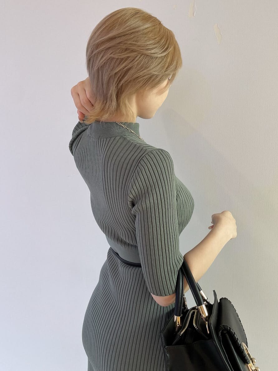 ブラック系のハンドバッグ、グリーン系のワンピース、ブラック系のパンプスを着用したレディースの夏コーディネートの6枚目の写真