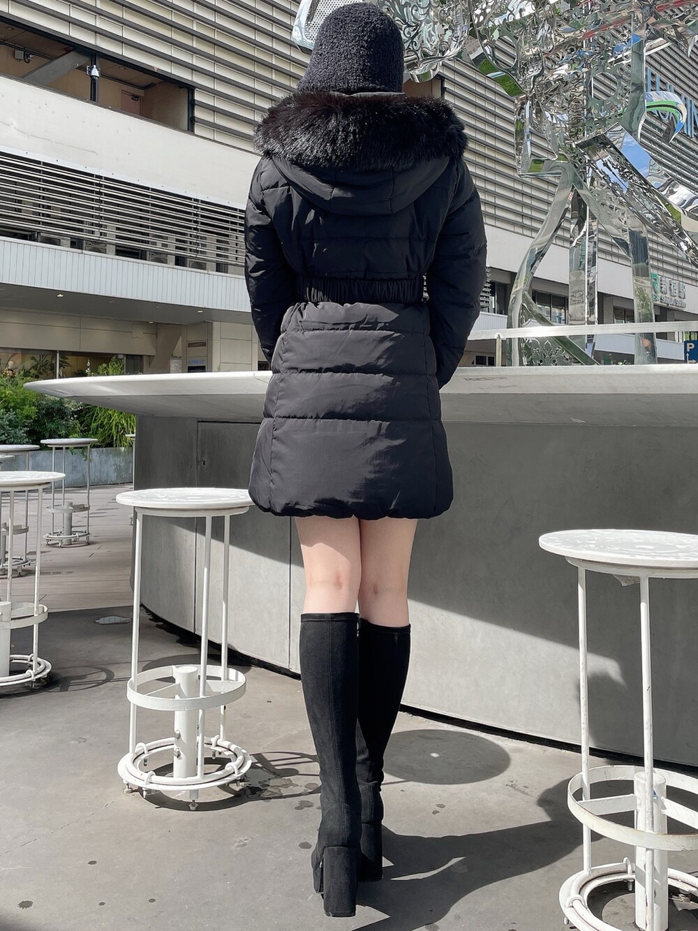 ブラック系のダウンジャケット/コート、ブラック系のブーツ、ブラック系のハットを着用したレディースの秋コーディネートの3枚目の写真