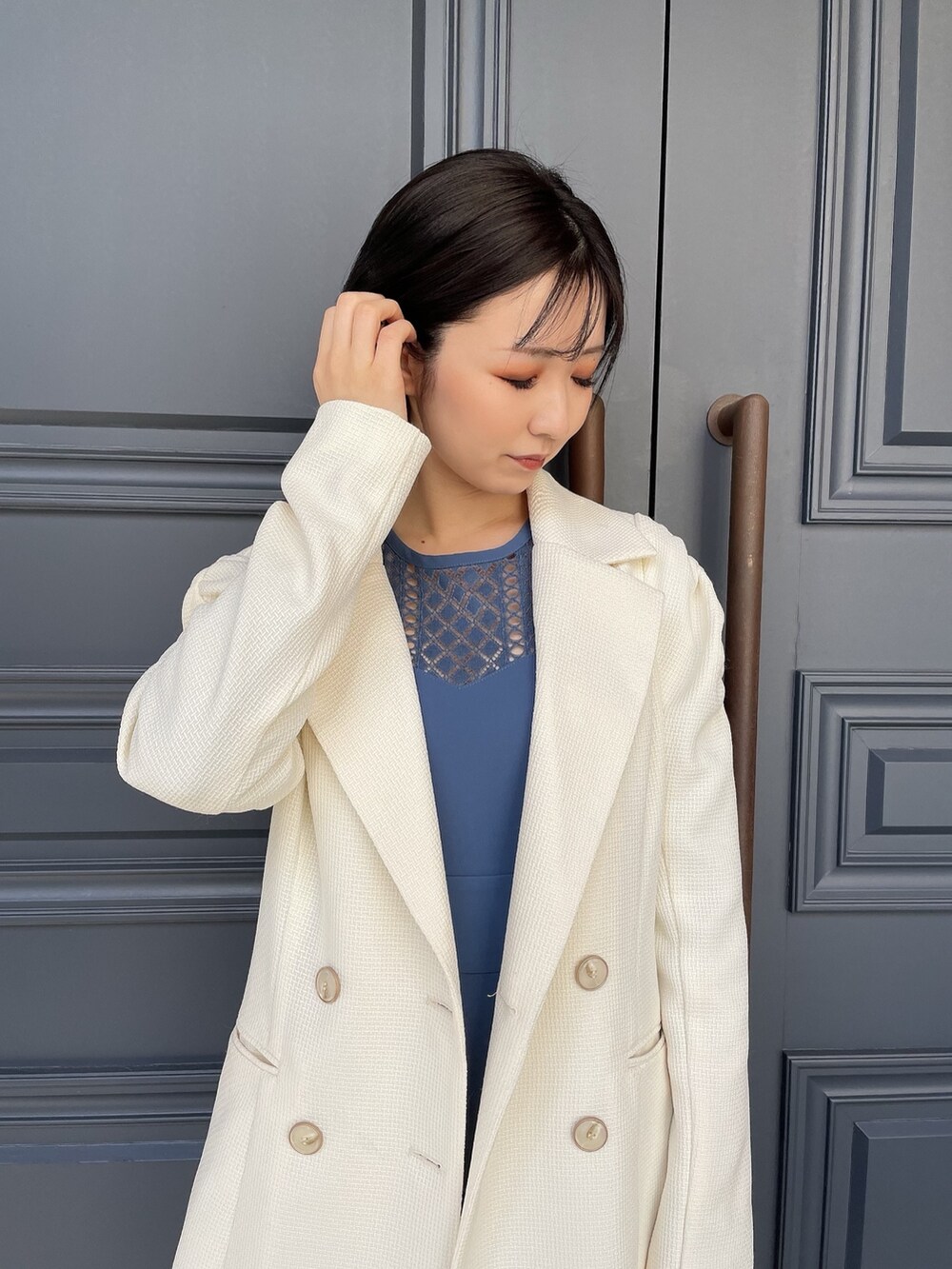 ホワイト系のテーラードジャケット、ブラウン系のハンドバッグ、ホワイト系のパンプスを着用したレディースの春コーディネートの7枚目の写真