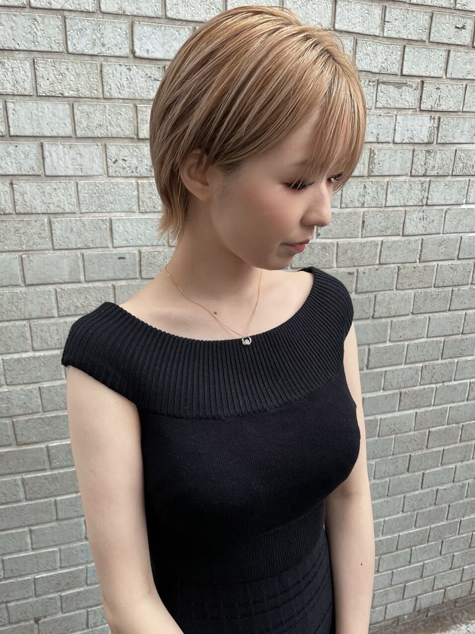 ブラック系のワンピース、ブラック系のサンダル、ベージュ系のハンドバッグを着用したレディースの夏コーディネートの5枚目の写真