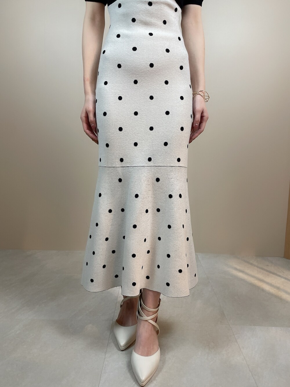 ブラック系のワンピース、ホワイト系のパンプスを着用したレディースの冬コーディネートの7枚目の写真