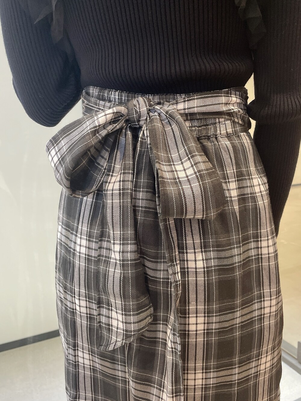 ブラック系のニット/セーター、その他のスカート、ブラック系のブーツを着用したレディースの冬コーディネートの6枚目の写真