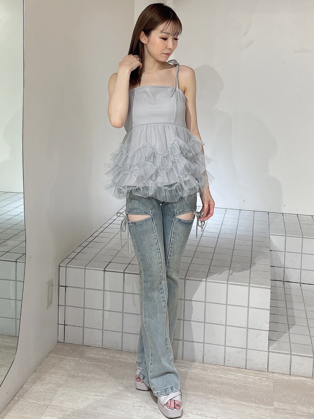 ブルー系のキャミソール、ブルー系のデニムパンツ、ベージュ系のサンダルを着用したレディースの夏コーディネートの2枚目の写真