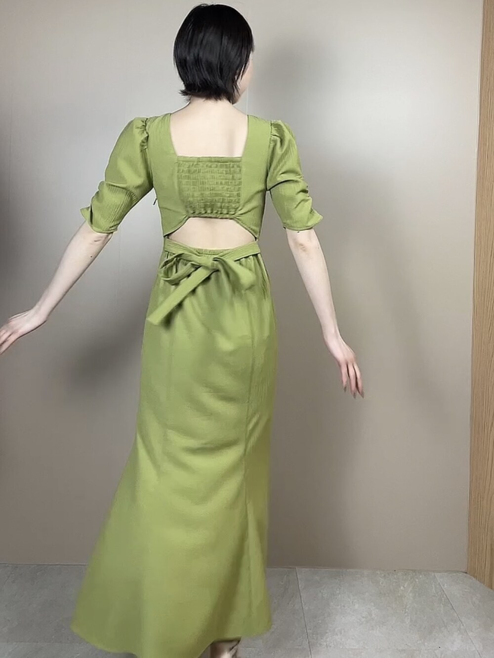 ホワイト系のサンダル、グリーン系のワンピースを着用したレディースの春コーディネートの3枚目の写真