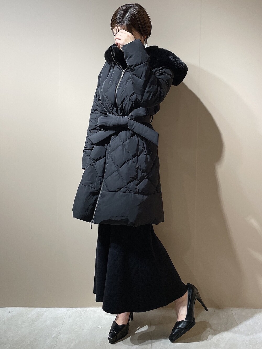 ブラック系のダウンジャケット/コート、ブラック系のワンピース、ブラック系のパンプスを着用したレディースの秋コーディネートの4枚目の写真