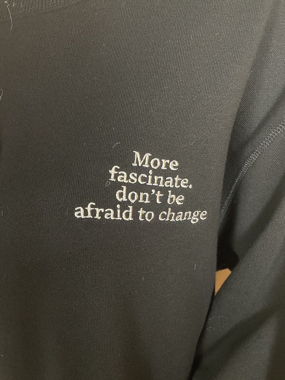 ホワイト系のスカート、ブラウン系のブーツ、ブラック系のスウェットを着用したレディースの夏コーディネートの6枚目の写真