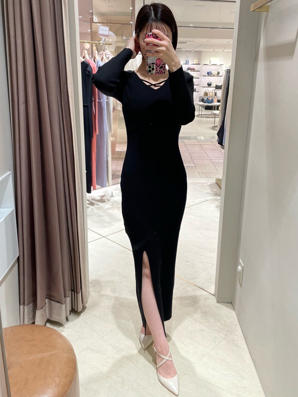 ブラック系のワンピース、ホワイト系のパンプスを着用したレディースの冬コーディネートの3枚目の写真