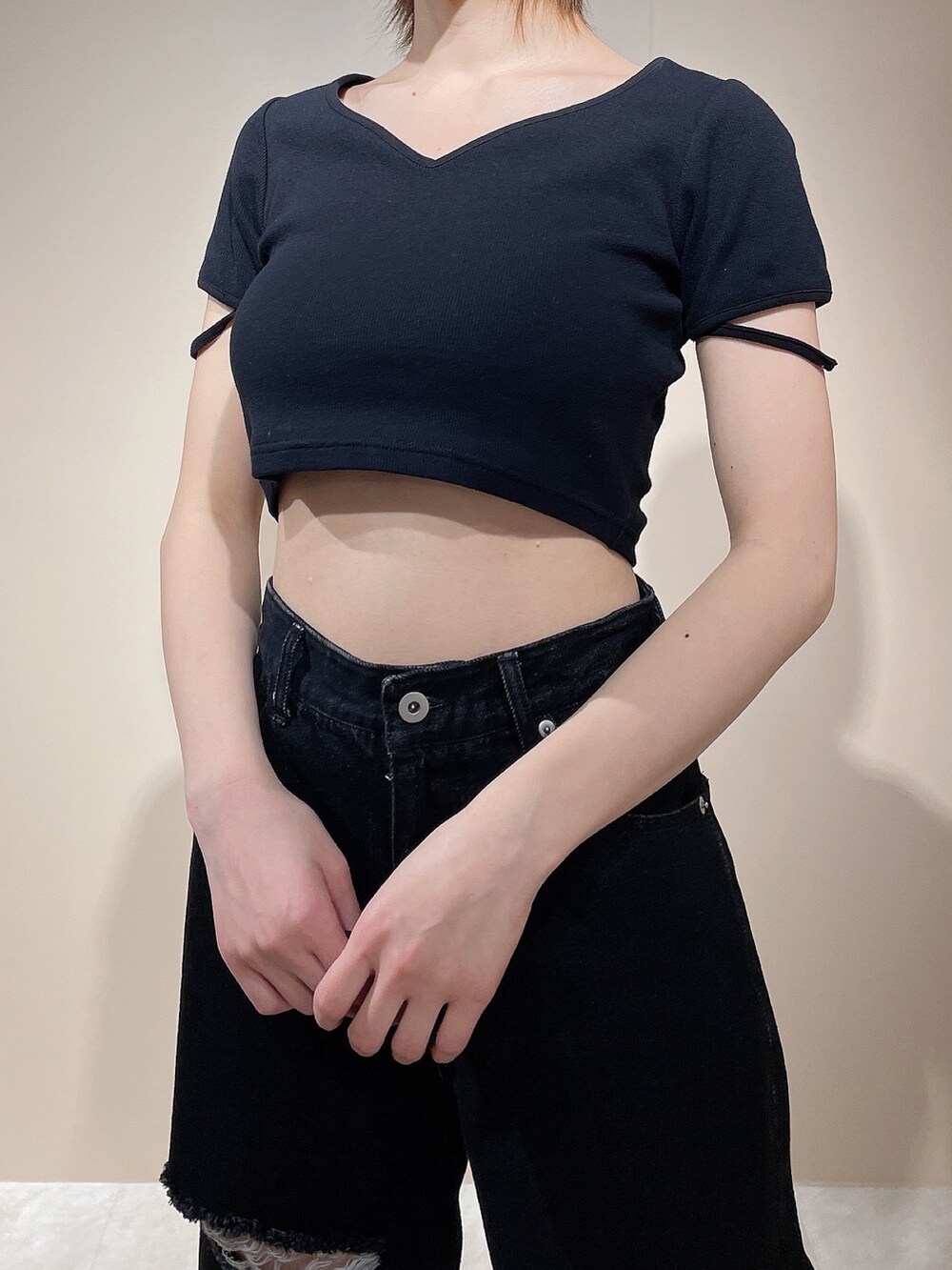 ブラック系のTシャツ/カットソー、ブラック系のデニムパンツ、ブラック系のサンダルを着用したレディースの春コーディネートの6枚目の写真