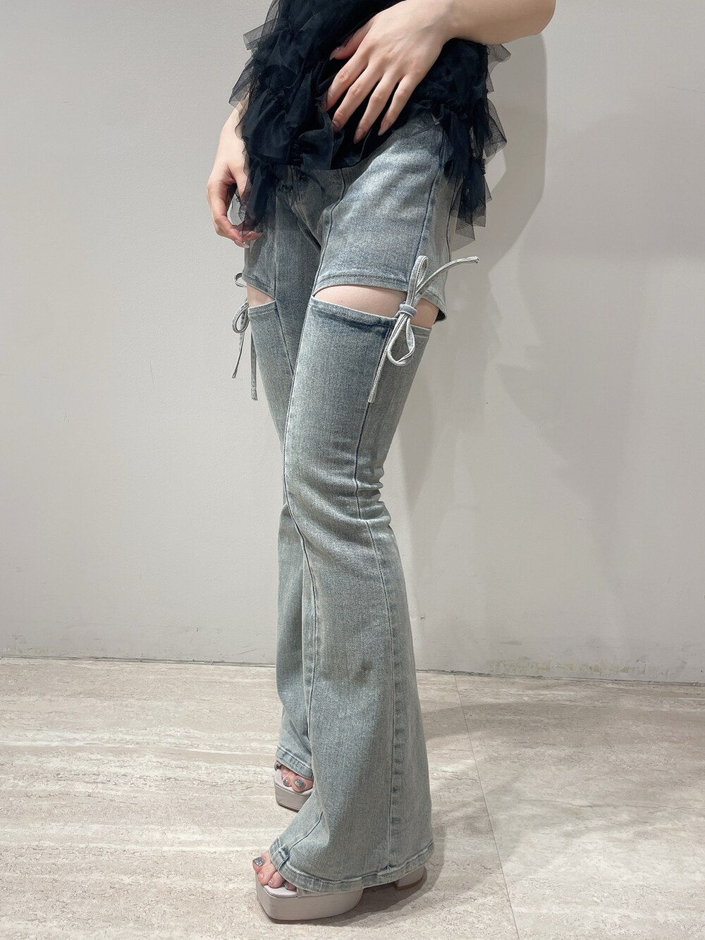 ブラック系のキャミソール、ブルー系のデニムパンツ、ベージュ系のサンダルを着用したレディースの夏コーディネートの7枚目の写真