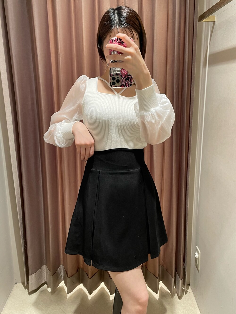 ホワイト系のニット/セーター、ブラック系のスカート、ブラック系のブーツを着用したレディースの冬コーディネートの5枚目の写真