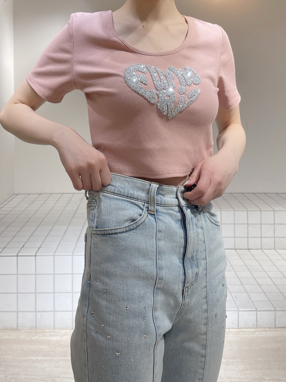 ピンク系のTシャツ/カットソー、ブルー系のデニムパンツ、ホワイト系のサンダルを着用したレディースの春コーディネートの6枚目の写真