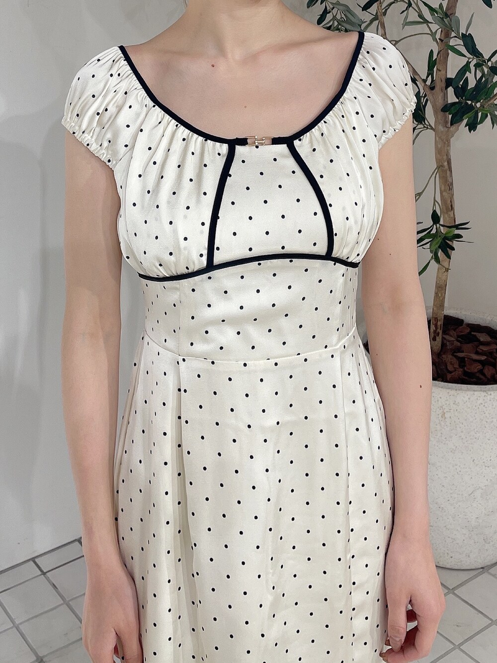 ホワイト系のワンピース、ベージュ系のサンダル、ベージュ系のシュシュを着用したレディースの春コーディネートの4枚目の写真