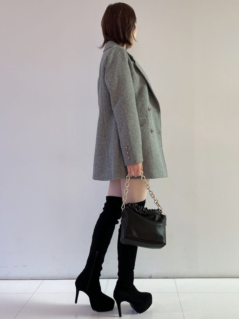 ブラック系のブーツ、グレー系のその他パンツ、ブラック系のハンドバッグを着用したレディースの秋コーディネートの3枚目の写真