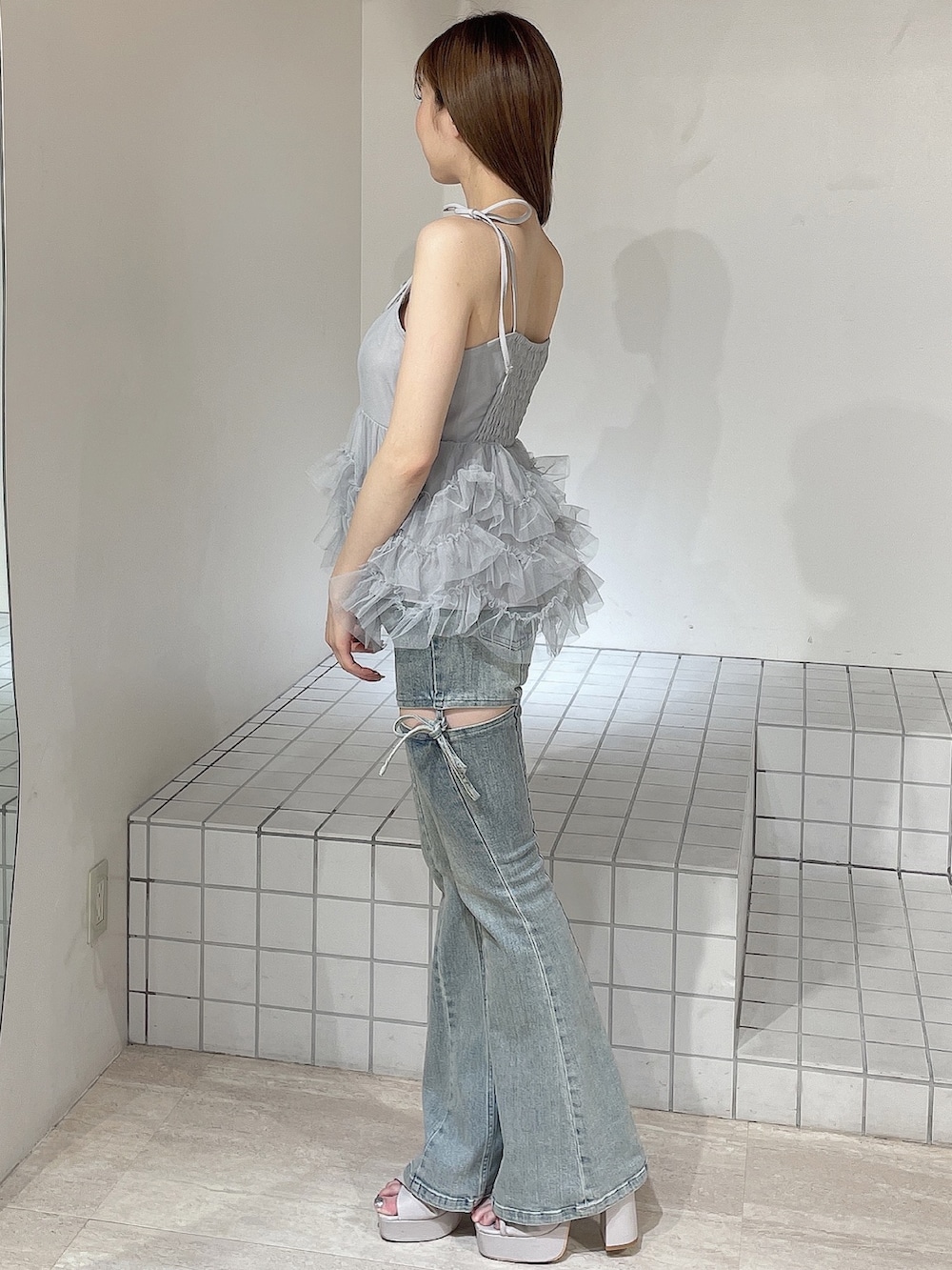 ブルー系のキャミソール、ブルー系のデニムパンツ、ベージュ系のサンダルを着用したレディースの夏コーディネートの3枚目の写真