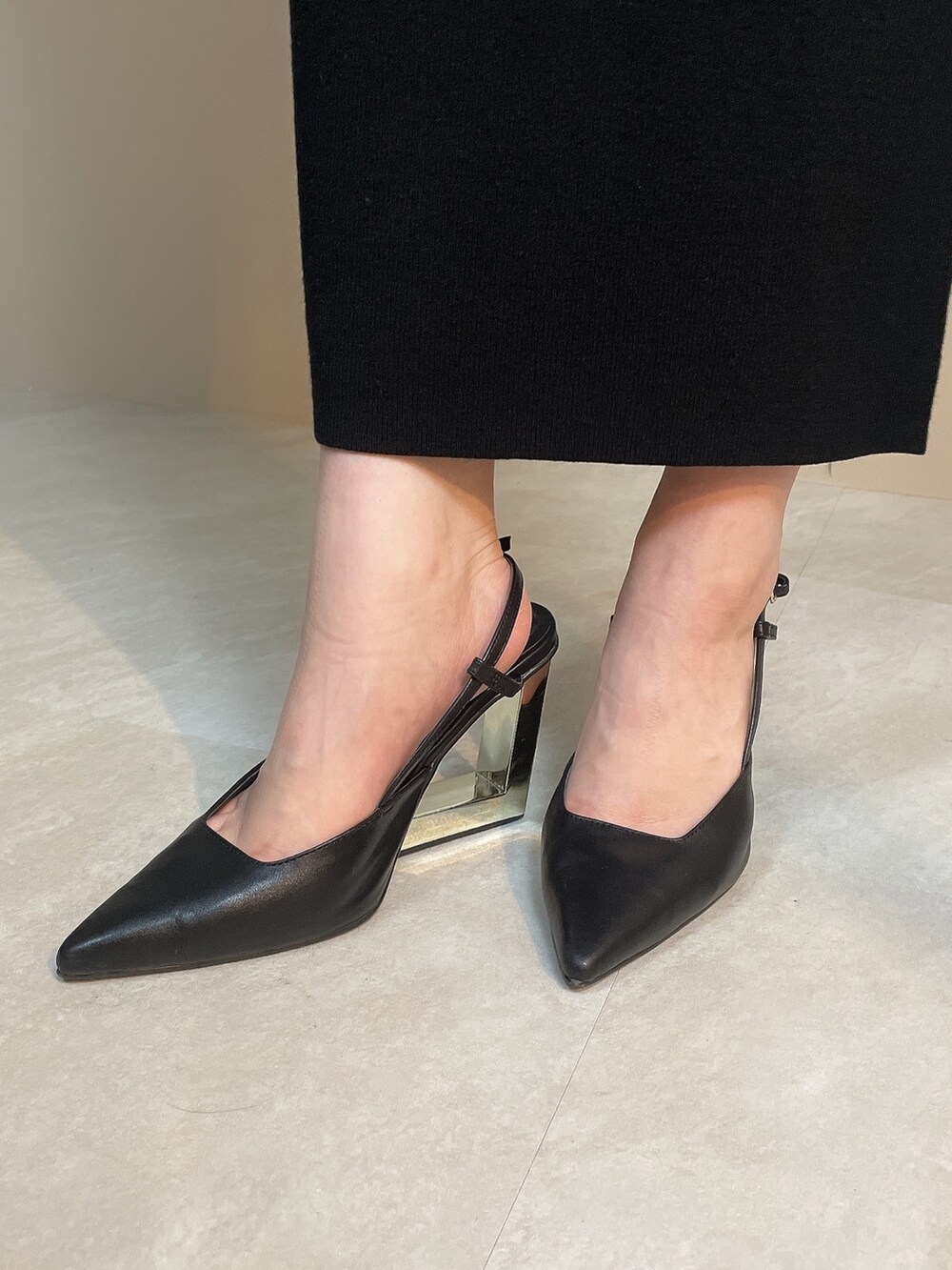 ブラック系のニット/セーター、ブラック系のスカート、ブラック系のサンダルを着用したレディースの夏コーディネートの8枚目の写真