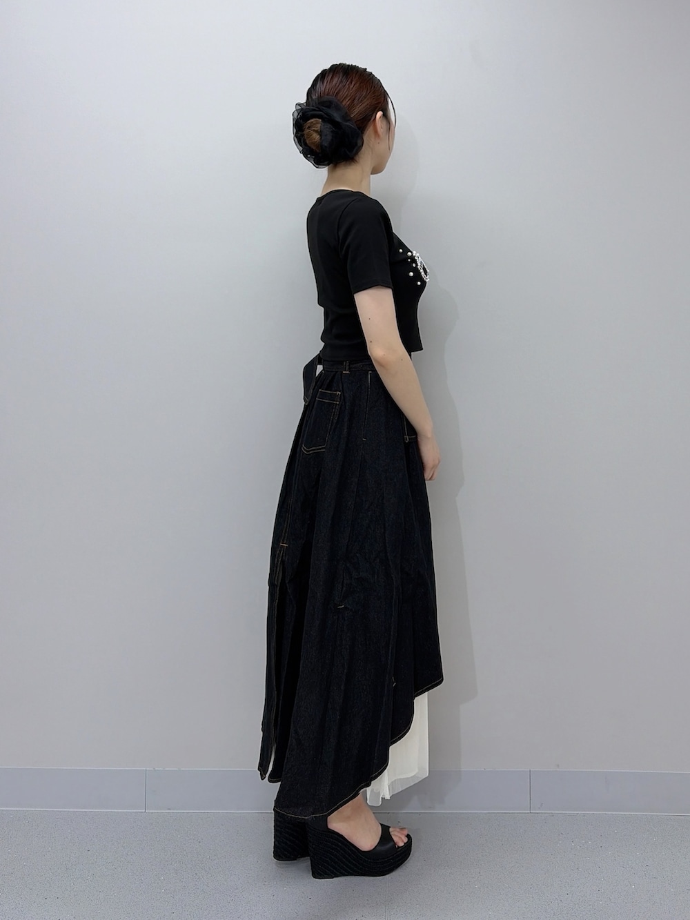 ブラック系のTシャツ/カットソー、ブラック系のスカート、ブラック系のサンダルを着用したレディースの夏コーディネートの3枚目の写真