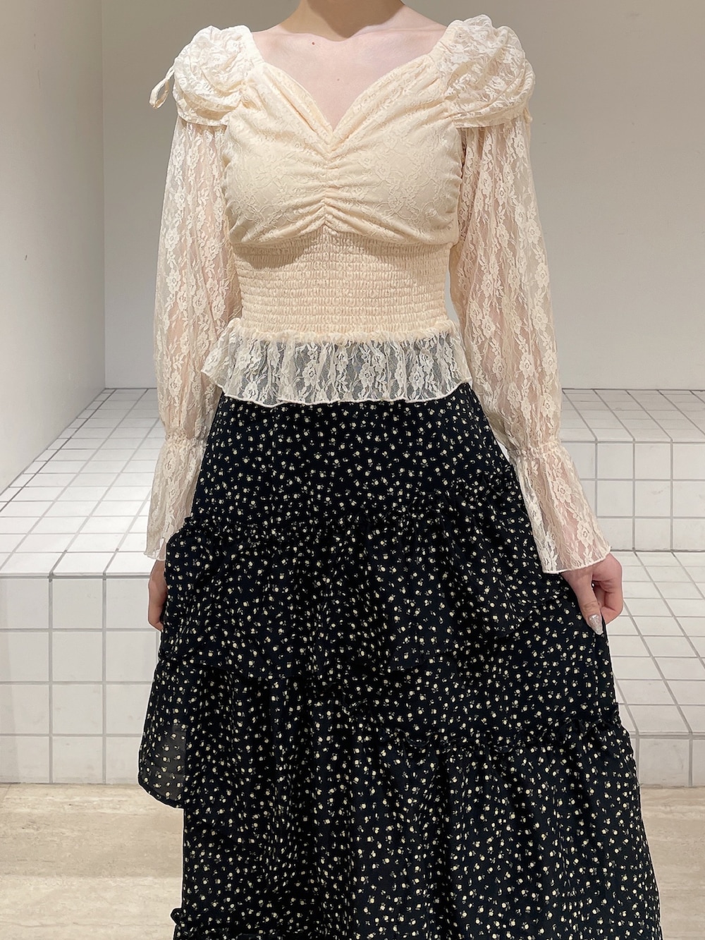 オレンジ系のシャツ/ブラウス、ブラック系のスカート、ホワイト系のパンプスを着用したレディースの春コーディネートの7枚目の写真