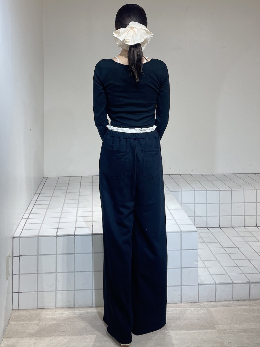 ブラック系のTシャツ/カットソー、ブラック系のその他パンツ、ホワイト系のパンプスを着用したレディースの春コーディネートの3枚目の写真