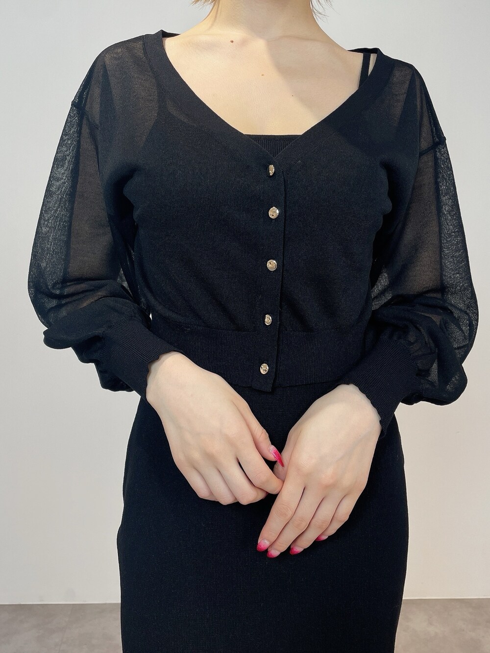 ブラック系のワンピース、ブラック系のパンプスを着用したレディースの冬コーディネートの6枚目の写真