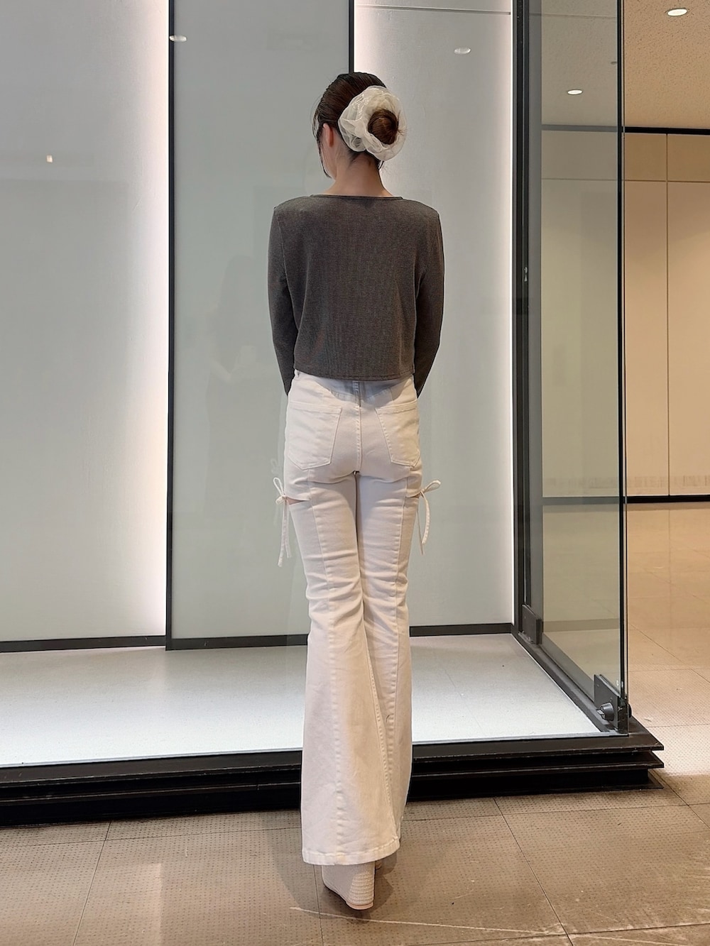 グレー系のTシャツ/カットソー、ホワイト系のデニムパンツ、ホワイト系のサンダルを着用したレディースの夏コーディネートの3枚目の写真