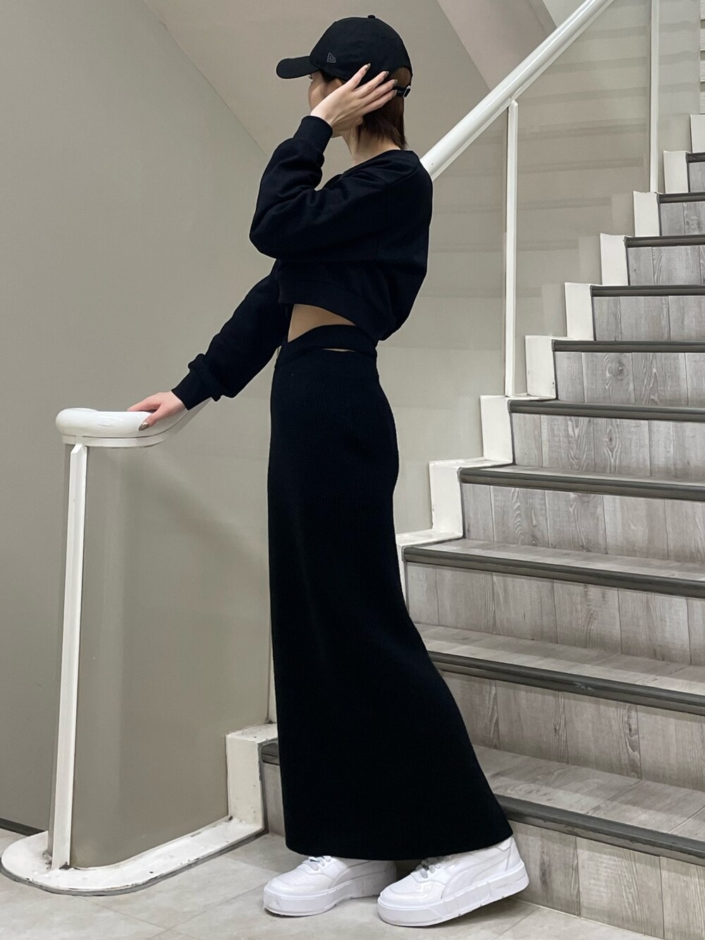 ホワイト系のスニーカー、ブラック系のスウェット、ブラック系のスカートを着用したレディースの冬コーディネートの2枚目の写真