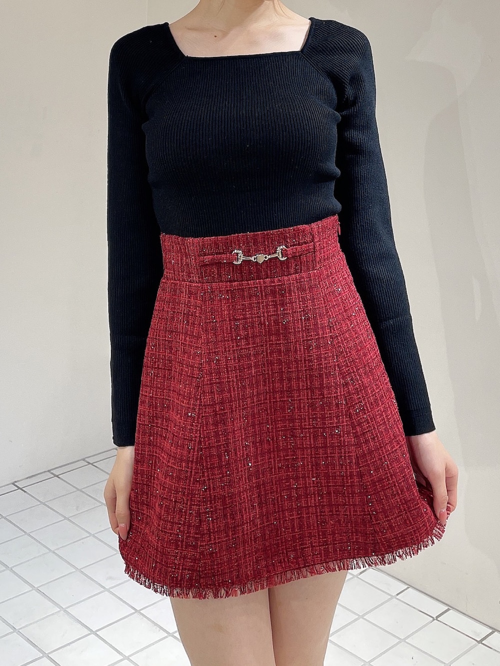 レッド系のテーラードジャケット、レッド系のスカート、ブラック系のニット/セーターを着用したレディースの秋コーディネートの6枚目の写真