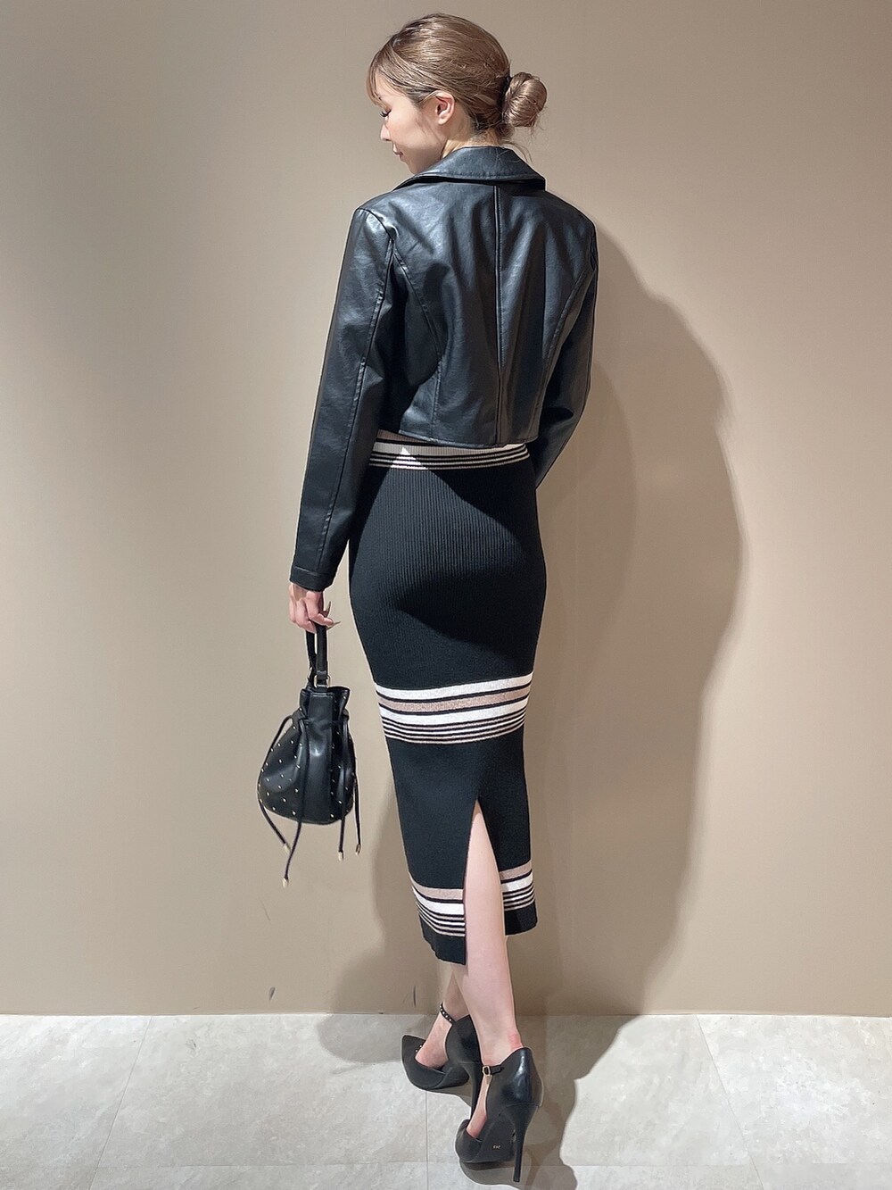 ブラック系のライダースジャケット、その他のワンピース、ブラック系のハンドバッグを着用したレディースの秋コーディネートの4枚目の写真