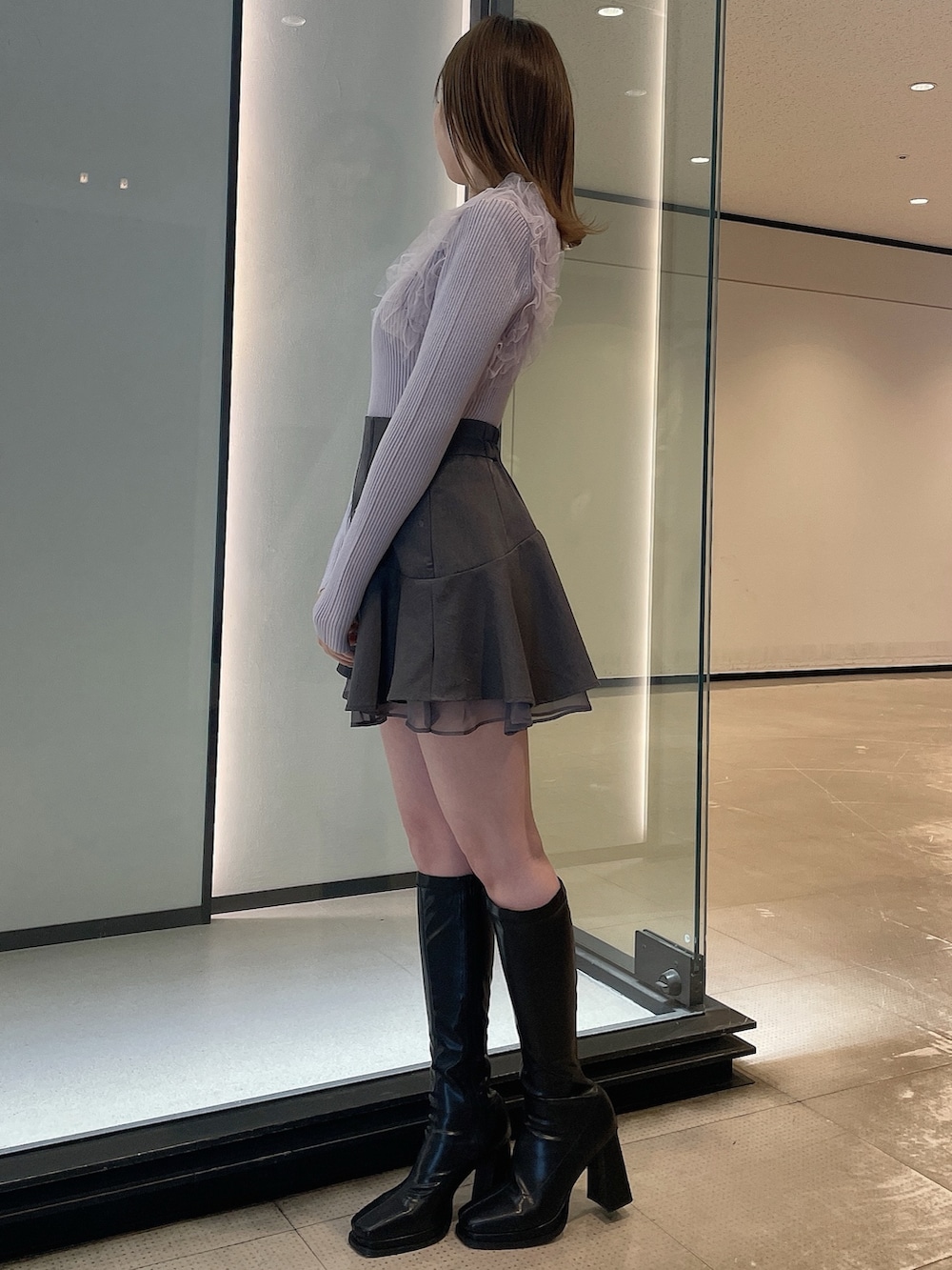 ブラック系のブーツ、グレー系のスカート、パープル系のニット/セーターを着用したレディースの冬コーディネートの3枚目の写真