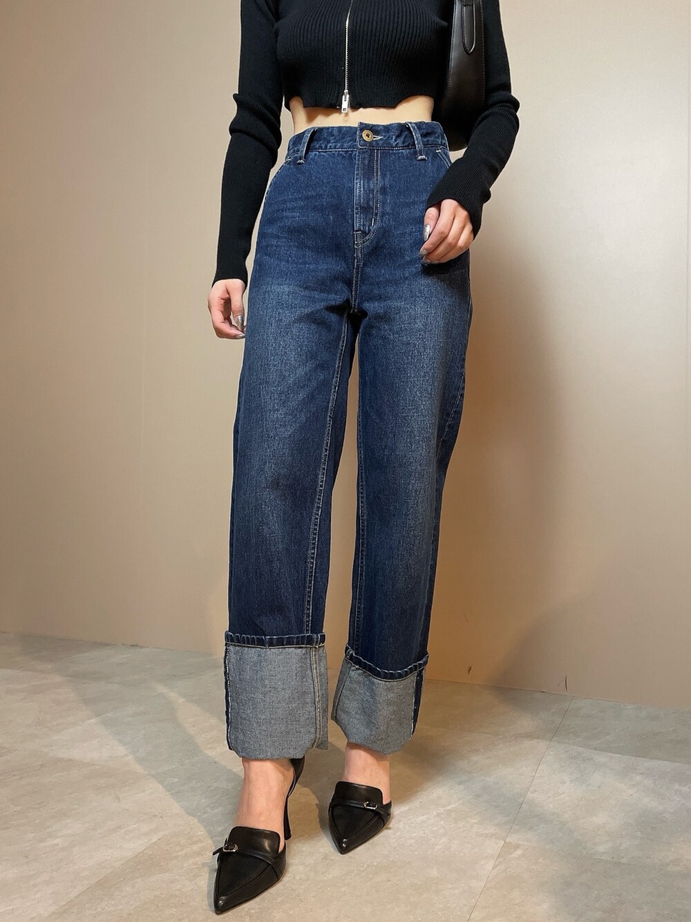 ブラック系のニット/セーター、ブルー系のデニムパンツ、ブラック系のハンドバッグを着用したレディースの冬コーディネートの9枚目の写真