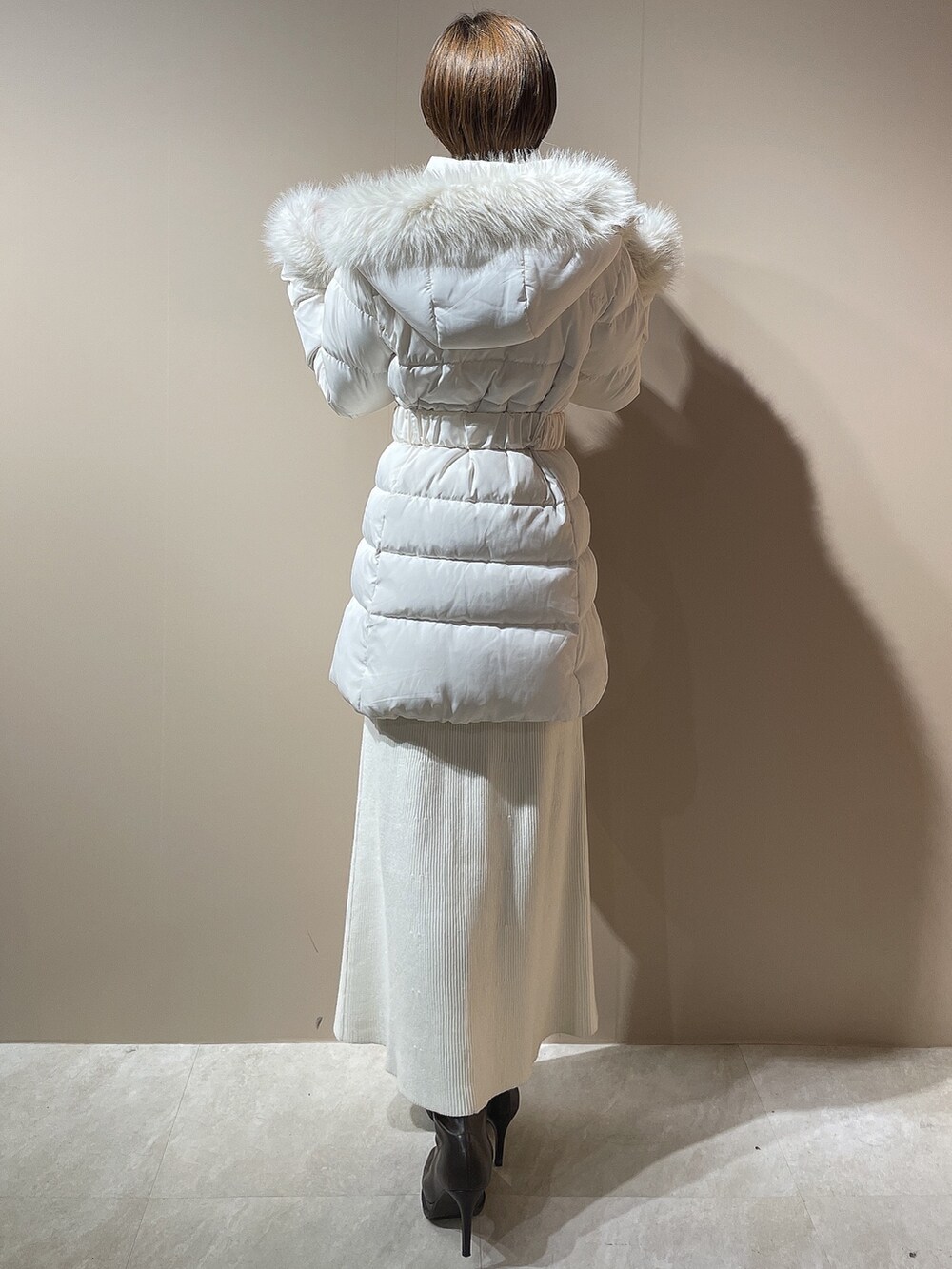 ホワイト系のダウンジャケット/コート、ホワイト系のワンピース、ブラウン系のブーツを着用したレディースの秋コーディネートの4枚目の写真