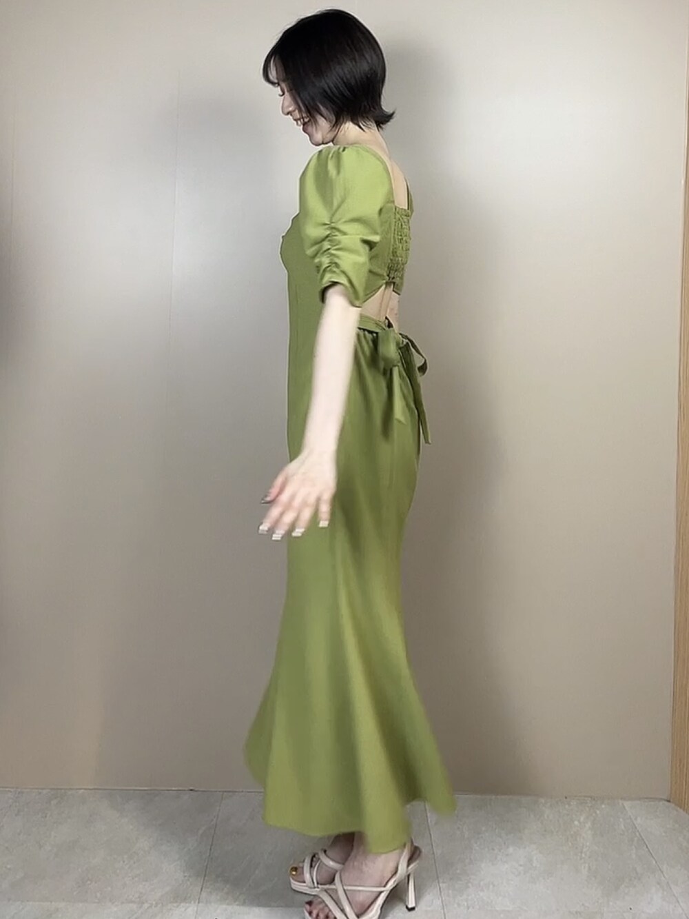 ホワイト系のサンダル、グリーン系のワンピースを着用したレディースの春コーディネートの2枚目の写真