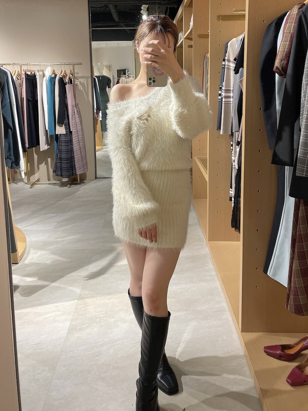 ホワイト系のワンピース、ブラック系のブーツを着用したレディースの秋コーディネートの9枚目の写真