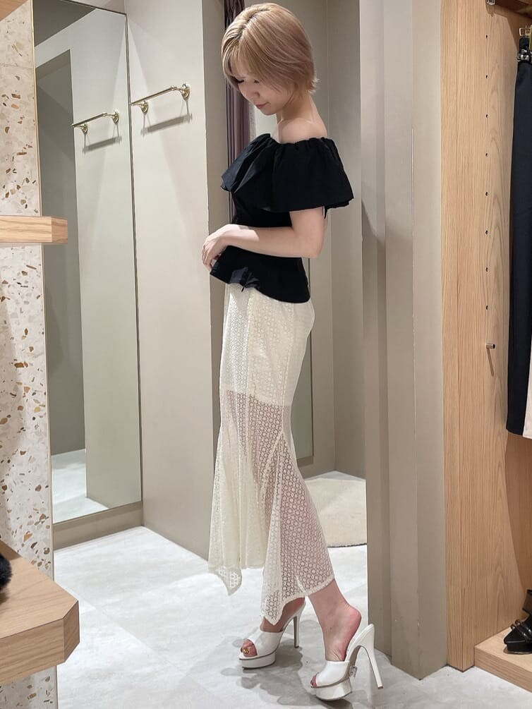 ホワイト系のスカート、ブラック系のシャツ/ブラウス、ホワイト系のサンダルを着用したレディースの夏コーディネートの2枚目の写真