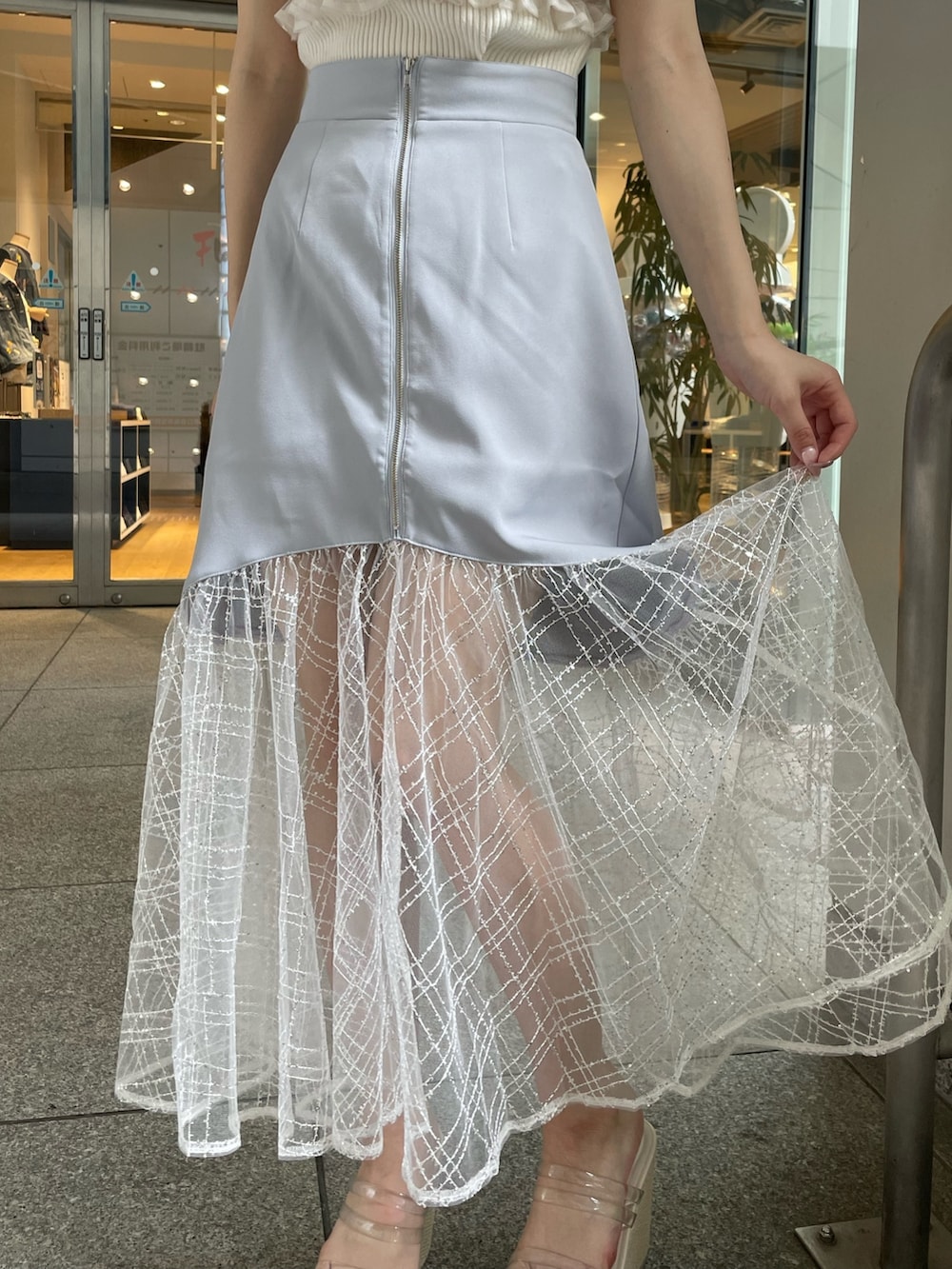 ホワイト系のシャツ/ブラウス、ブルー系のスカート、ホワイト系のサンダルを着用したレディースの夏コーディネートの7枚目の写真