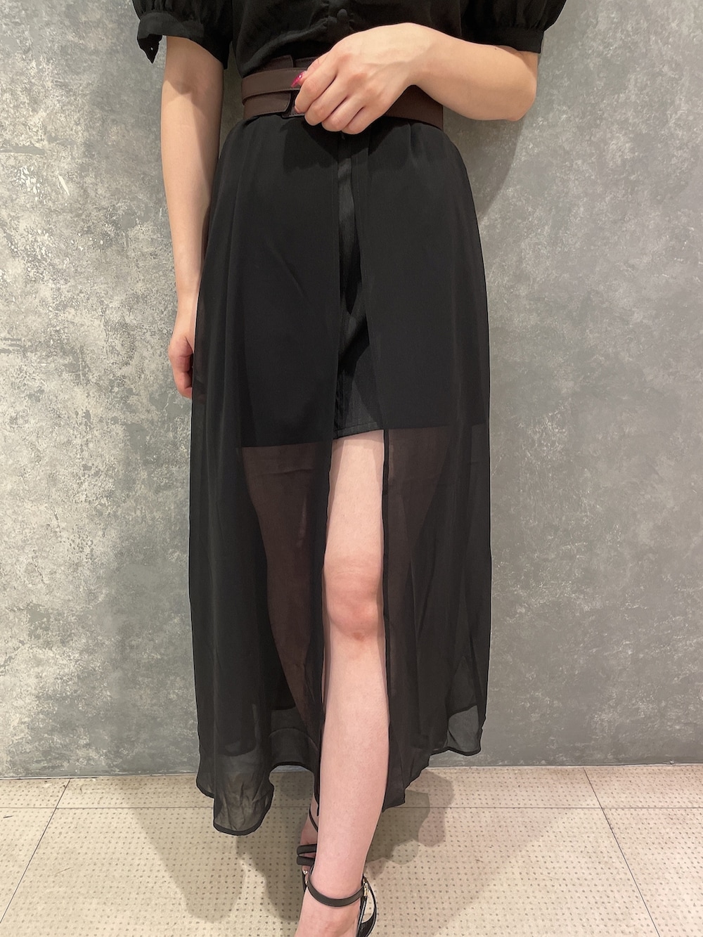 ブラック系のワンピース、ブラック系のサンダル、ブラウン系のベルトを着用したレディースの夏コーディネートの7枚目の写真