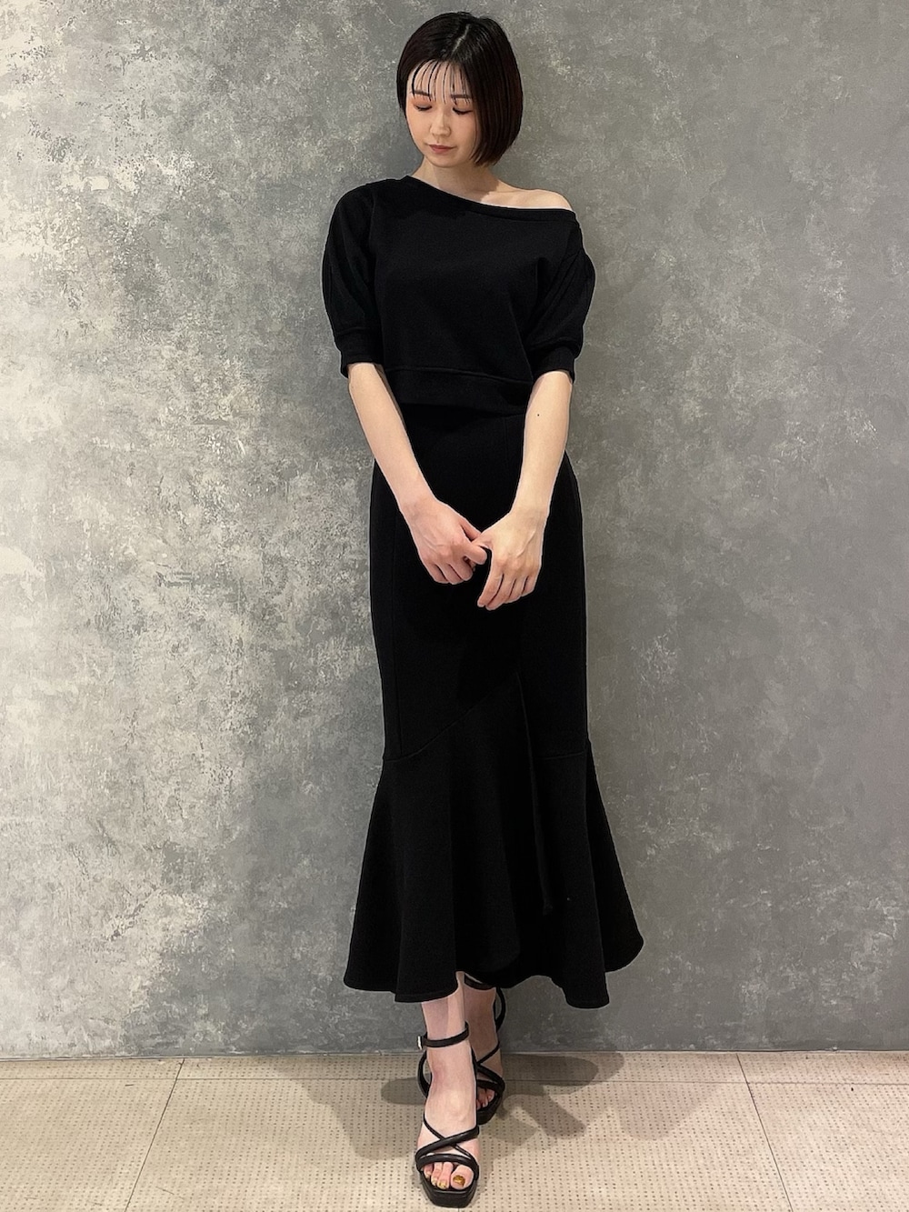 ブラック系のサンダル、ブラック系のスカート、ブラック系のスウェットを着用したレディースの春コーディネートの2枚目の写真