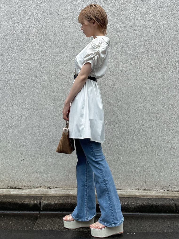 ホワイト系のサンダル、ベージュ系のハンドバッグ、ブルー系のデニムパンツを着用したレディースの夏コーディネートの2枚目の写真