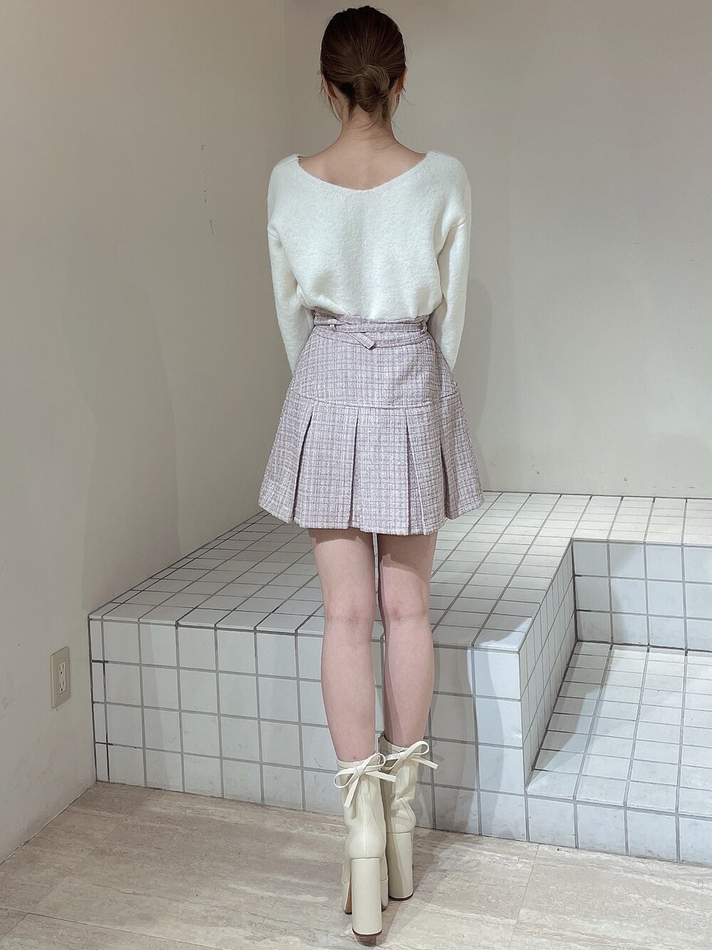 ピンク系のその他アウター、ピンク系のスカート、ホワイト系のニット/セーターを着用したレディースの冬コーディネートの7枚目の写真