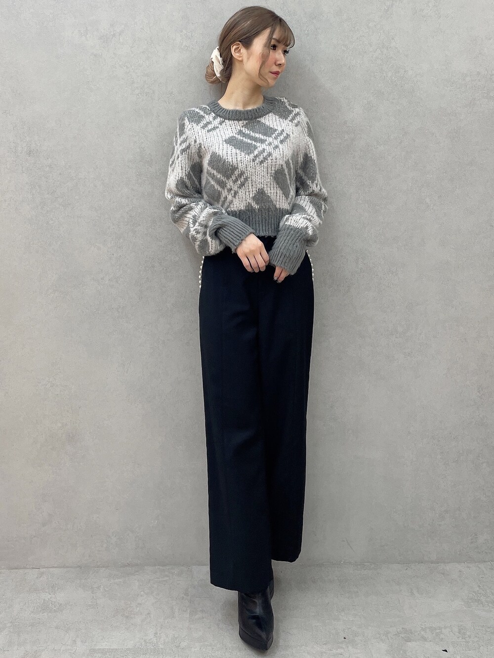 グレー系のニット/セーター、ブラック系のその他パンツ、ブラック系のブーツを着用したレディースの秋コーディネートの4枚目の写真