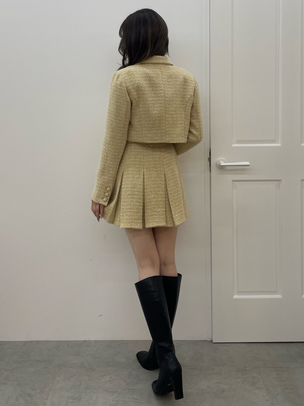 イエロー系のテーラードジャケット、イエロー系のスカート、ホワイト系のTシャツ/カットソーを着用したレディースの秋コーディネートの3枚目の写真