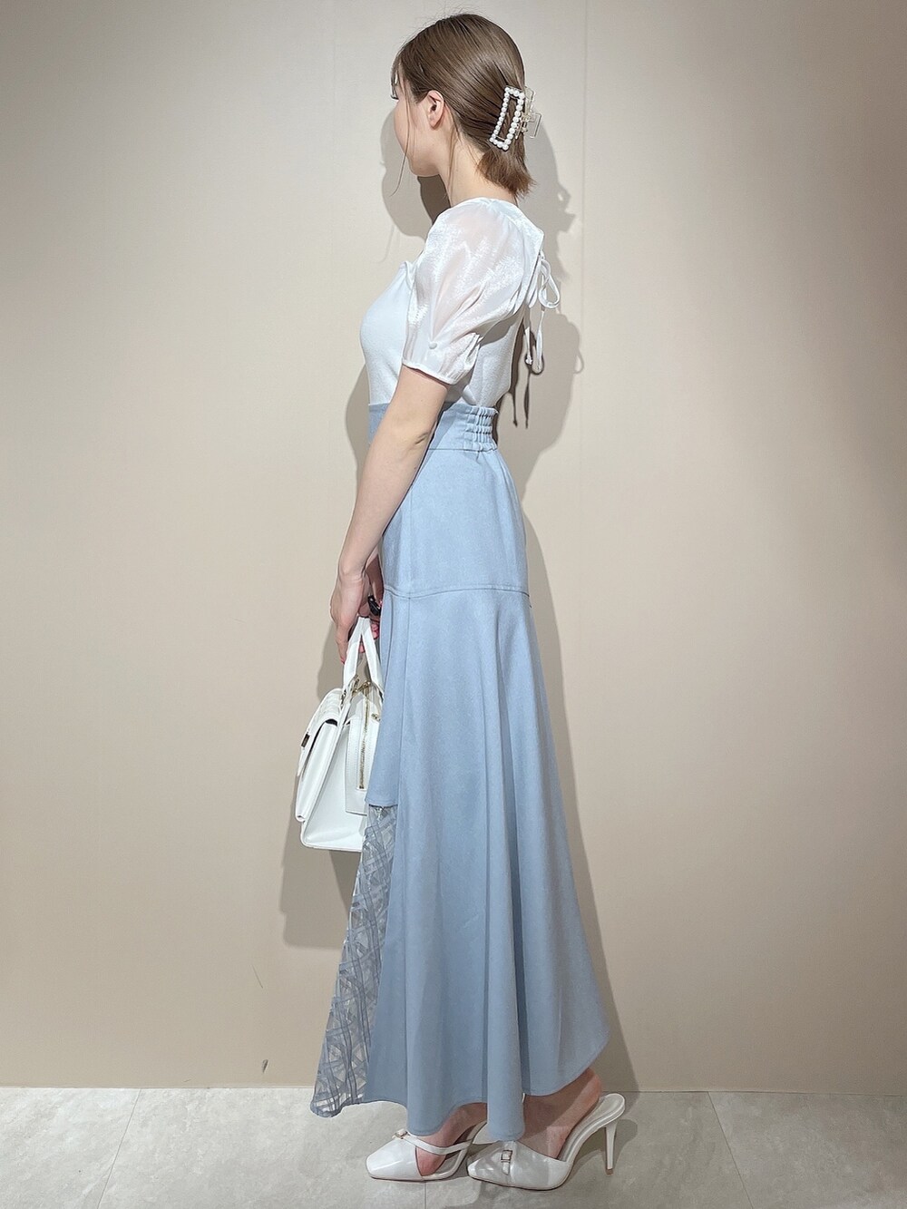 ホワイト系のニット/セーター、ブルー系のスカートを着用したレディースの春コーディネートの3枚目の写真