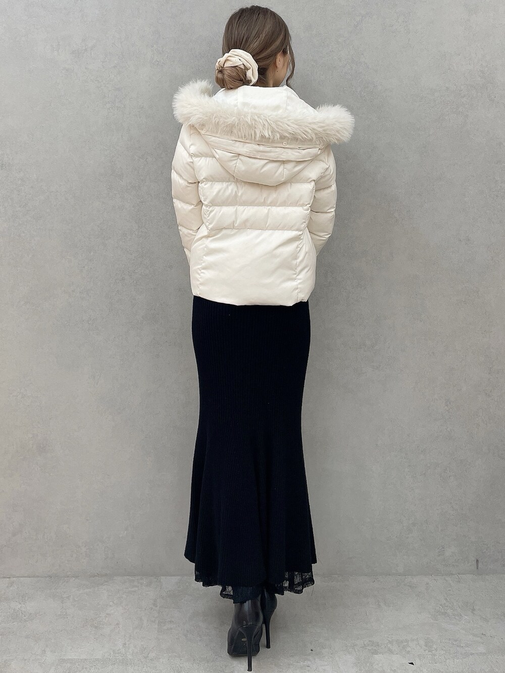 ホワイト系のダウンジャケット/コート、ブラック系のワンピース、ブラック系のブーツを着用したレディースの秋コーディネートの3枚目の写真