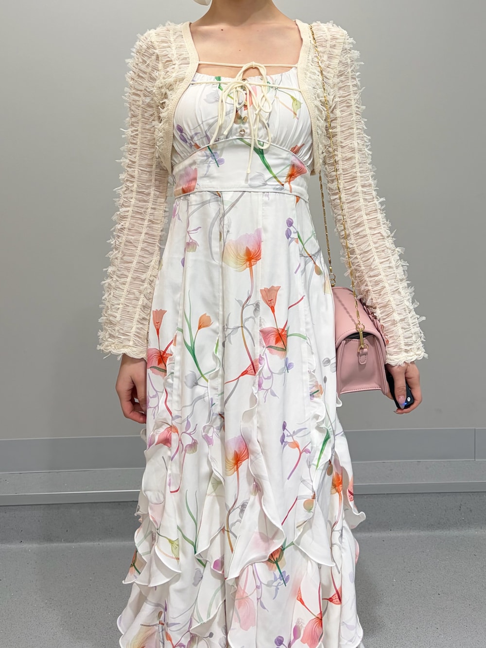 ホワイト系のワンピース、ピンク系のショルダーバッグ、ホワイト系のパンプスを着用したレディースの冬コーディネートの4枚目の写真