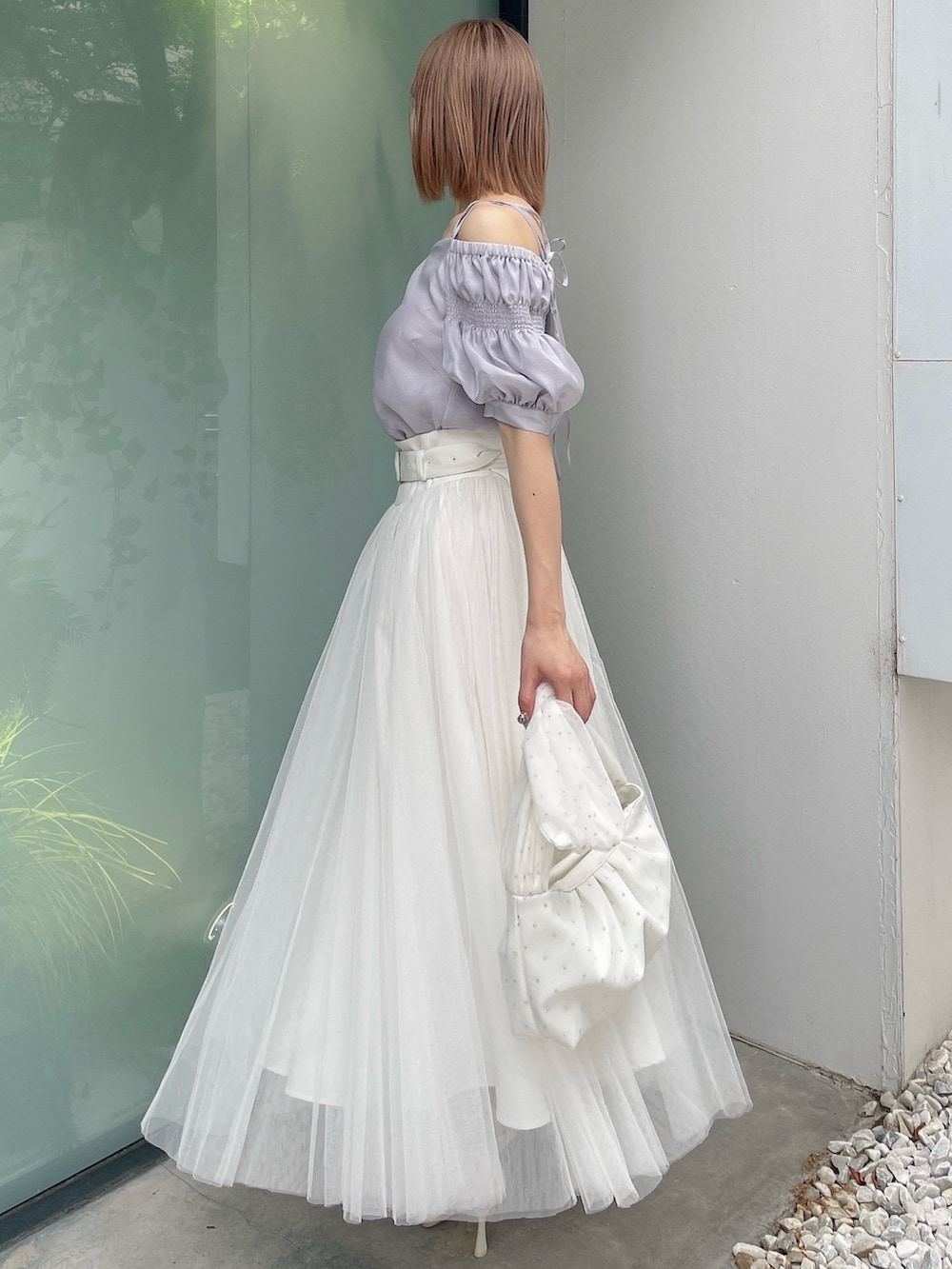 ホワイト系のスカート、ホワイト系のハンドバッグ、パープル系のシャツ/ブラウスを着用したレディースの夏コーディネートの3枚目の写真