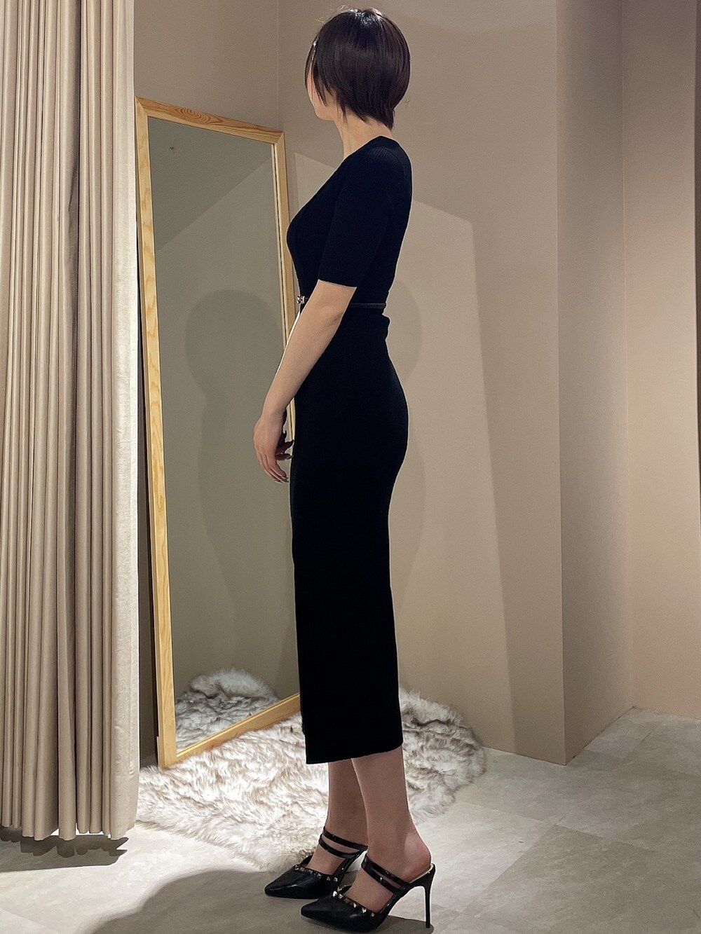 ブラック系のワンピース、ブラック系のパンプス、ブラック系のベルトを着用したレディースの春コーディネートの5枚目の写真