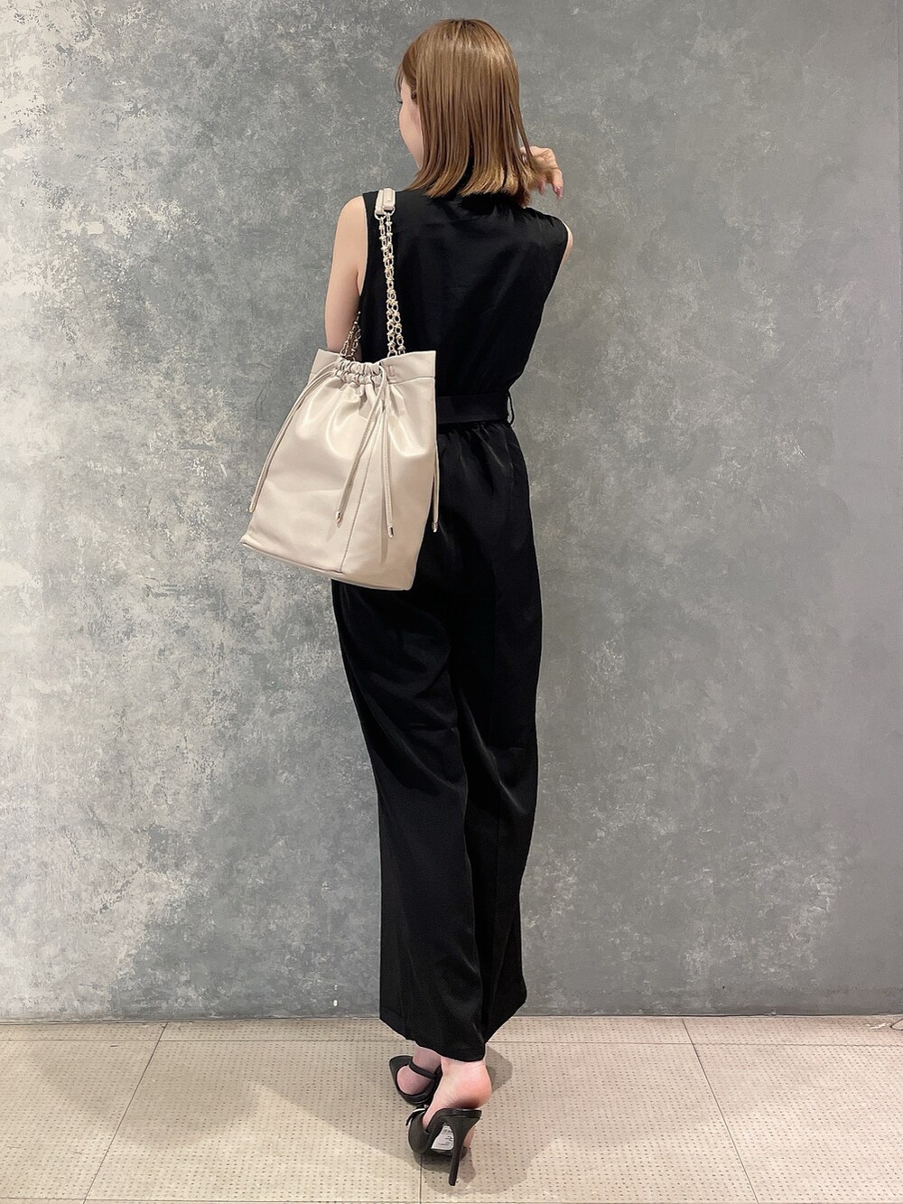 ブラック系のつなぎ/オールインワン、ベージュ系のトートバッグ、ブラック系のスリッポンを着用したレディースの夏コーディネートの4枚目の写真