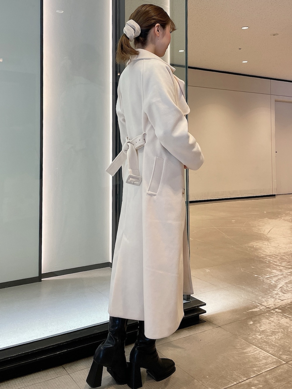 ホワイト系のその他アウター、ブラック系のワンピース、ブラック系のブーツを着用したレディースの冬コーディネートの2枚目の写真