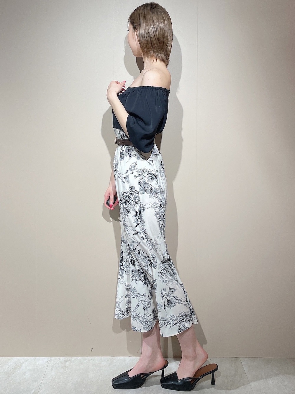 ブラック系のワンピース、ブラック系のパンプス、ブラウン系のベルトを着用したレディースの春コーディネートの5枚目の写真